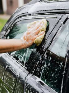 Man cleaning car windows to make sure there are no streaks