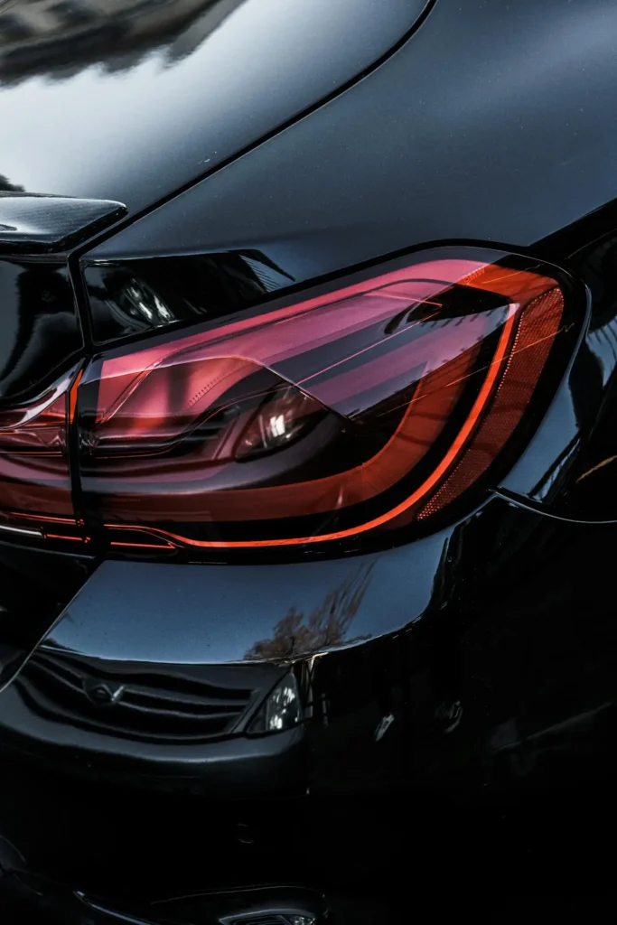 A close up view of the tail light and bumper of a clean black car